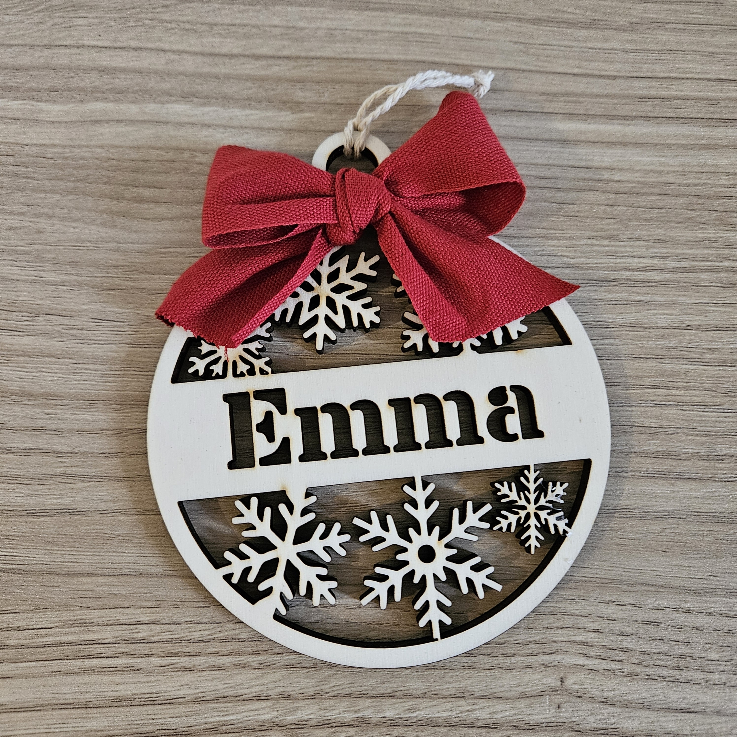 Pallina di Natale con nome intagliato e fiocco